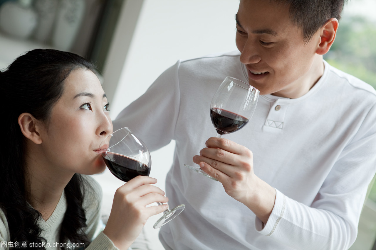 一对夫妻甜蜜品红酒